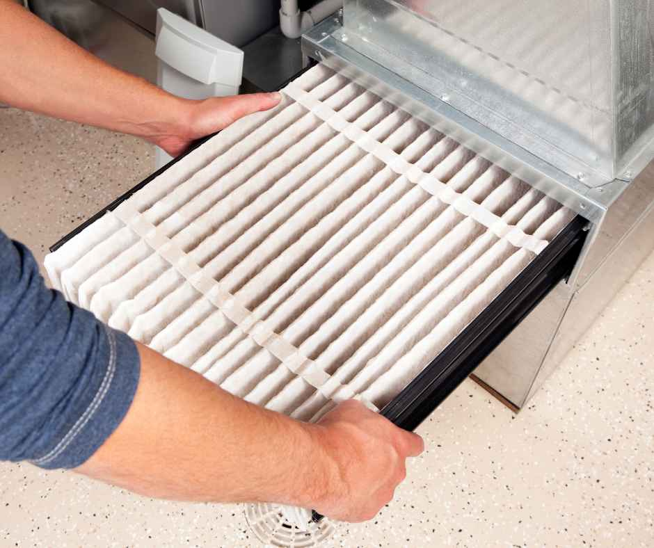 A person installing a new furnace filter